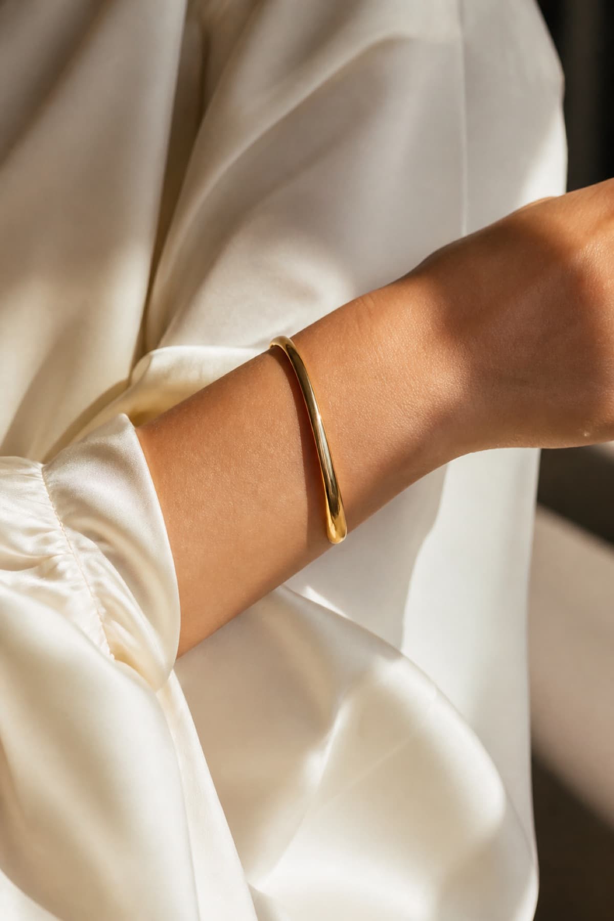 Gold-tone cuff on the wrist